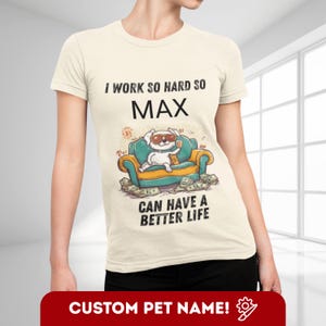 Könnte beinhalten: Cremefarbenes T-Shirt mit dem Text "I WORK SO HARD SO MAX CAN HAVE A BETTER LIFE". Die Grafik zeigt einen Cartoon-Hund mit Sonnenbrille, der auf einem türkis-goldenen Sofa mit Geld liegt. Unten steht auf einem roten Banner "CUSTOM PET NAME!"