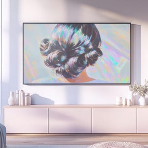 May include: A large framed artwork depicts the back of a woman's head with dark, styled hair. The artwork is mounted above a light pink cabinet with white vases and decorative items. The room has a modern, minimalist aesthetic.