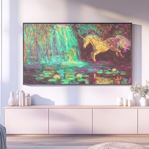 May include: A framed artwork depicts a golden unicorn leaping over a pond with lily pads, set against a vibrant waterfall. The painting features a colorful, dreamlike landscape with a black frame, suitable for home decor.