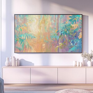 Pode incluir: Obra de arte emoldurada de grandes dimensões com uma colorida cena de selva abstrata com folhas de palmeira em tons de turquesa, amarelo e laranja. A obra está pendurada acima de um armário rosa claro com vasos e decoração brancos.