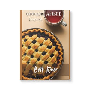 May include: A journal titled "Odd Job Annie" with a pie and a cup of tea. The pie has a lattice crust and dark filling. The journal cover has the text "Odd Job Annie Journal" and "Beth Riner". A cup of tea is at the top.