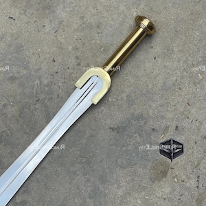 Op de afbeelding: Een gedetailleerde afbeelding van een zwaard met een zilveren lemmet en een goudkleurig handvat. Het handvat heeft een cilindrische greep en een afgeronde pommel. De pareerstang is een U-vormig ontwerp in een gouden tint. Het zwaard staat tegen een neutrale achtergrond.