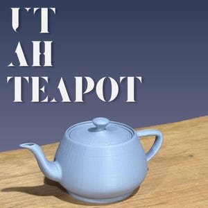 Könnte beinhalten: Eine hellblaue 3D-gedruckte Teekanne mit Deckel, Ausguss und Henkel. Der Text "IT AH TEAPOT" steht über der Teekanne und "3D PRINTED" darunter. Die Teekanne steht auf einer Holzoberfläche.