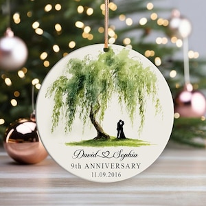Puede incluir: Adorno redondo de cerámica blanca con una pintura de acuarela de un sauce llorón. Debajo del árbol, una pareja está silueteada. El adorno está inscrito con "David & Sophia" y "9th ANNIVERSARY 11.09.2016".