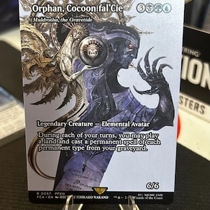 Pode incluir: Carta colecionável com o personagem "Orphan, Cocoon fal'Cie" de Final Fantasy XIII. A carta apresenta uma ilustração detalhada de uma criatura com pele escura, garras longas e elementos de design intrincados. O texto inclui "Legendary Creature - Elemental Avatar".