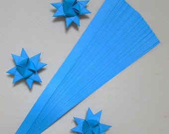 May include: A stack of 50 light blue paper strips for origami. Three origami stars are made from the paper strips. The stars are a light blue color.