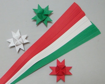 May include: A set of red, white, and green paper strips for origami. The strips are arranged in a fan shape, with the red strips on top, the white strips in the middle, and the green strips on the bottom. There are three origami stars made from the paper strips, one red, one white, and one green.