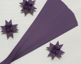 May include: A stack of 50 sheets of purple origami paper. The paper is folded into three-dimensional stars.