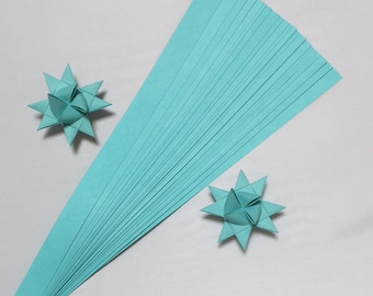May include: A pack of 25 teal origami paper strips, with two folded origami stars made from the paper.