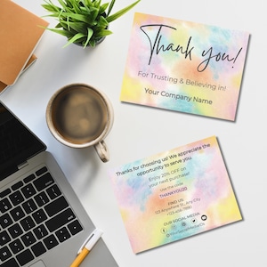 Puede incluir: Dos tarjetas cuadradas con fondos de acuarela en colores pastel, una con "Thank you!" y la otra con un mensaje de agradecimiento e iconos de redes sociales. Un portátil, una taza de café y una planta sobre una superficie blanca.