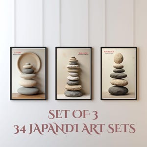 K&ouml;nnte beinhalten: Drei gerahmte Kunstdrucke mit Stein-Arrangements. Jedes Bild zeigt eine andere Anordnung von Steinen, mit japanischem Text. Der Text "SET OF 3 34 JAPANDI ART SETS" ist in Burgunderfarbe am unteren Bildrand zu sehen.