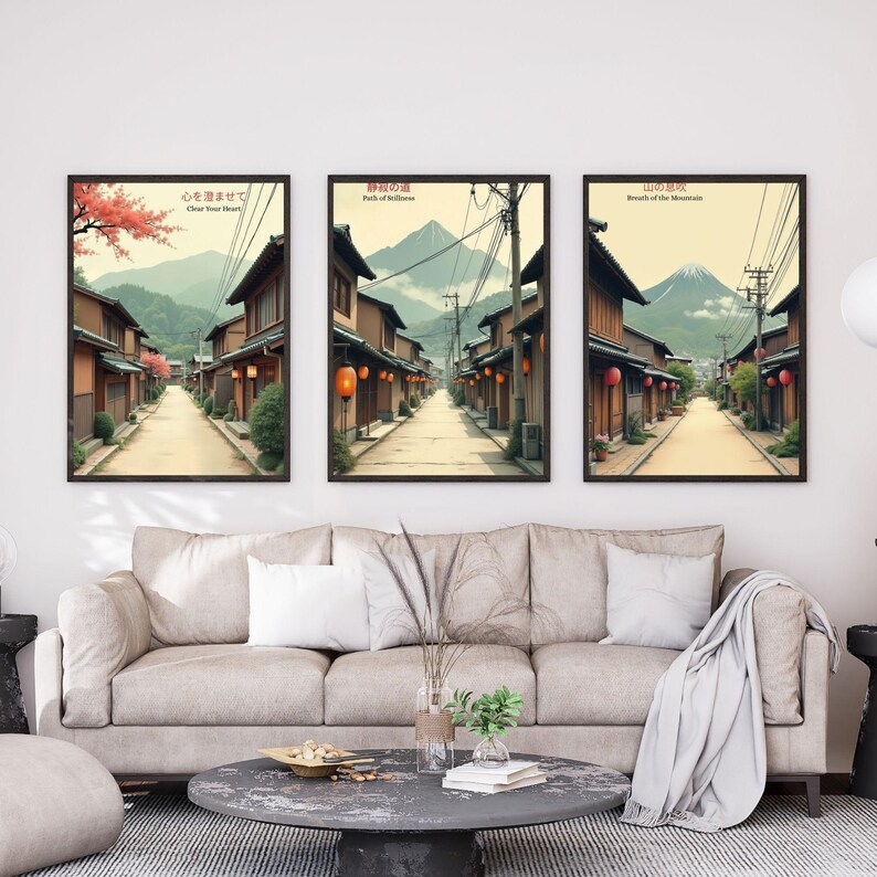 K&ouml;nnte beinhalten: Drei gerahmte Kunstdrucke mit japanischen Stra&szlig;enszenen. Jeder Druck zeigt eine perspektivische Ansicht einer Stra&szlig;e mit traditionellen Geb&auml;uden, mit Bergen im Hintergrund. Die Drucke haben japanischen Text. Die Drucke werden &uuml;ber einem beigen Sofa angezeigt.