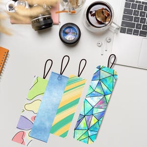 Pu&ograve; includere: Quattro segnalibri colorati con anelli neri. I segnalibri presentano disegni astratti nelle tonalit&agrave; di blu, verde, giallo e viola. Un segnalibro ha un motivo geometrico, mentre altri hanno disegni ad acquerello e fantasia.