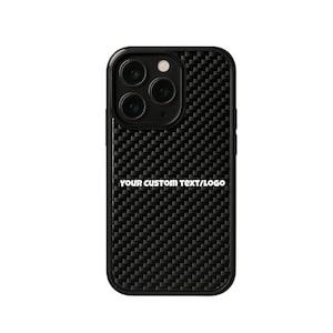 May include: Black phone case with a carbon fiber texture and a rectangular camera module. The text "YOUR CUSTOM TEXT/LOGO" is printed in white on the lower portion of the case. The case is designed to fit a smartphone.