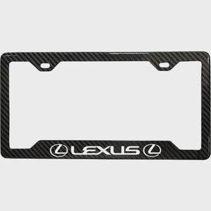 以下が含まれることがあります： 白い「LEXUS」ロゴが入った黒いカーボンファイバーのナンバープレートフレーム。フレームは長方形で角が丸く、取り付け穴があります。標準的な日本のナンバープレートに合うように設計されています。