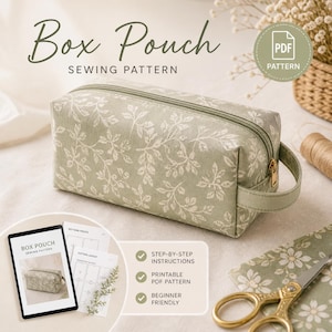 May include: A sage green box pouch sewing pattern with a white floral design. The pouch has a zipper closure and a small handle. The image includes a tablet with the pattern, instructions, and scissors. Text on the image says "Box Pouch Sewing Pattern".