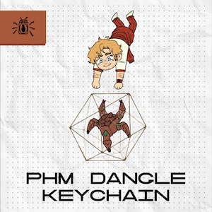 May include: A dangle keychain featuring a cartoon illustration of a blonde character in a white and red outfit above a brown, multi-legged creature encased in a geometric wireframe structure. The text PHM DANGLE KEYCHAIN is printed at the bottom.
