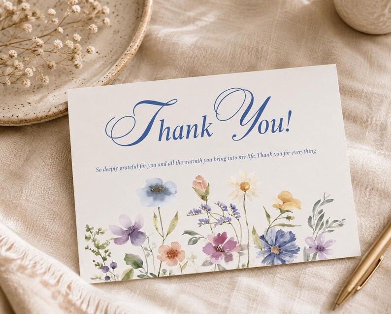 May include: A rectangular white greeting card featuring the blue script text Thank You! and the smaller printed message So deeply grateful for you and all the warmth you bring into my life. Thank you for everything, with watercolor wildflowers.