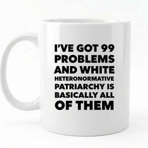 May include: White ceramic mug with black text. The text reads: "I've got 99 problems and white heteronormative patriarchy is basically all of them."