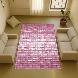 May include: A rectangular rug featuring a mosaic tile design in pink and white hues. The rug is set in a living room, with two beige sofas and a window in the background. The rug's design provides a modern aesthetic to the room.