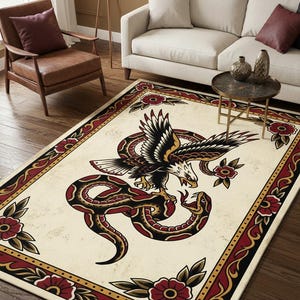 May include: A rectangular area rug featuring a cream-colored background with a central illustration of an eagle fighting a snake. The design includes a decorative border with red flowers and black leaves, rendered in a traditional tattoo art style.