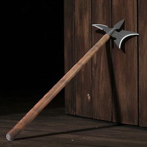 May include: A medieval polearm with a dark metal head and a wooden shaft. The head features a sharp axe blade, a spike, and a curved hook. The wooden shaft is a light brown color. The polearm is leaning against a wooden wall.