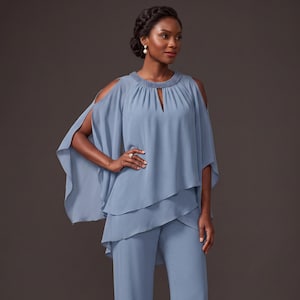 May include: A dusty blue two-piece pant suit featuring a layered chiffon tunic top with cold-shoulder cutouts, a beaded round neckline, and a small keyhole detail. The matching trousers are straight-legged with a clean, tailored silhouette.