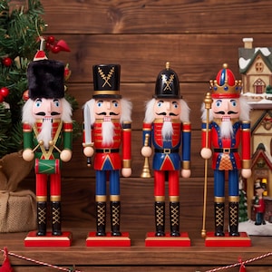May include: Four wooden nutcracker figurines standing in a row. The first wears a black fur hat and plays a green drum. The second holds a silver sword. The third carries a gold trumpet. The fourth wears a crown and holds a gold scepter.
