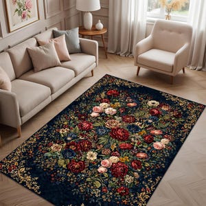 May include: A rectangular area rug with a dark blue background and a large floral pattern. The rug features a central bouquet of red, pink, and white flowers, surrounded by green leaves and smaller blossoms. The border has a gold and floral design.