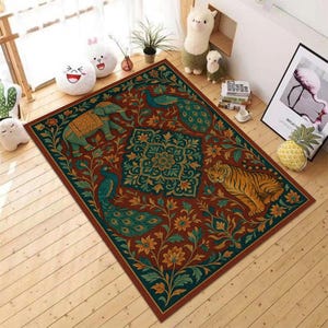 Puede incluir: Alfombra rectangular con un diseño detallado que presenta un elefante, un pavo real y un tigre sobre un fondo granate. La alfombra tiene un borde verde azulado y dorado y detalles florales. La alfombra está colocada sobre un suelo de madera.