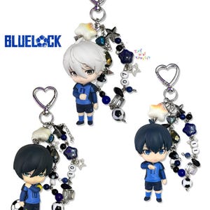 Könnte beinhalten: Drei Blue Lock Anime-Figuren-Schlüsselanhänger mit herzförmigen Verschlüssen. Jede zeigt eine Chibi-Figur in blauem Fußballtrikot, verziert mit Perlensträngen aus Sternen, Kugeln und Fußball-Anhängern. Der Text BLUELOCK ist sichtbar.