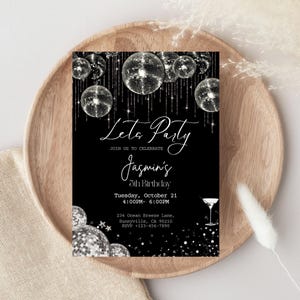May include: Black party invitation with silver disco balls and the text "Let's Party" and "Jasmin's 5th Birthday". Includes event details and RSVP information. The invitation is on a wooden plate.