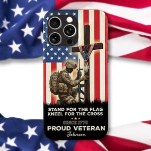 May include: A phone case featuring an American flag design with a soldier kneeling before a cross. The case includes the text "Stand for the flag, kneel for the cross, since 1776, proud veteran" and a name. The design incorporates red, white, and blue colors.