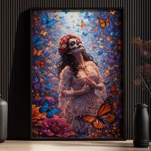 Könnte beinhalten: Gerahmter Kunstdruck mit einer Frau mit Day-of-the-Dead-Make-up, umgeben von Schmetterlingen in Blau-, Orange- und Rosatönen. Der Druck wird auf einer Holzoberfläche mit schwarzen Vasen präsentiert. Ein lebendiges Kunstwerk.