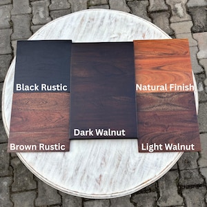 Op de afbeelding: Houten stalen met verschillende afwerkingen: Black Rustic, Dark Walnut, Natural Finish, Brown Rustic en Light Walnut. De stalen zijn gerangschikt op een witte, ronde tafel, waarbij de houtnerf en kleurvariaties worden getoond.