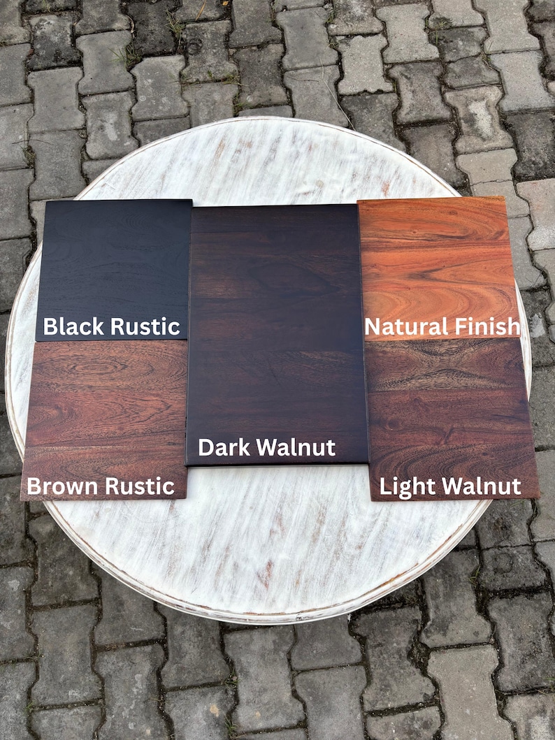 Op de afbeelding: Houten stalen met verschillende afwerkingen: Black Rustic, Dark Walnut, Natural Finish, Brown Rustic en Light Walnut. De stalen zijn gerangschikt op een witte, ronde tafel, waarbij de houtnerf en kleurvariaties worden getoond.