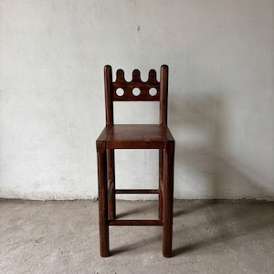 Pu&ograve; includere: Sgabello da bar in legno marrone scuro con schienale decorativo con tre intagli circolari. Lo sgabello ha una seduta quadrata e gambe robuste, che mostrano un design semplice e rustico. Lo sgabello &egrave; realizzato in legno massello.