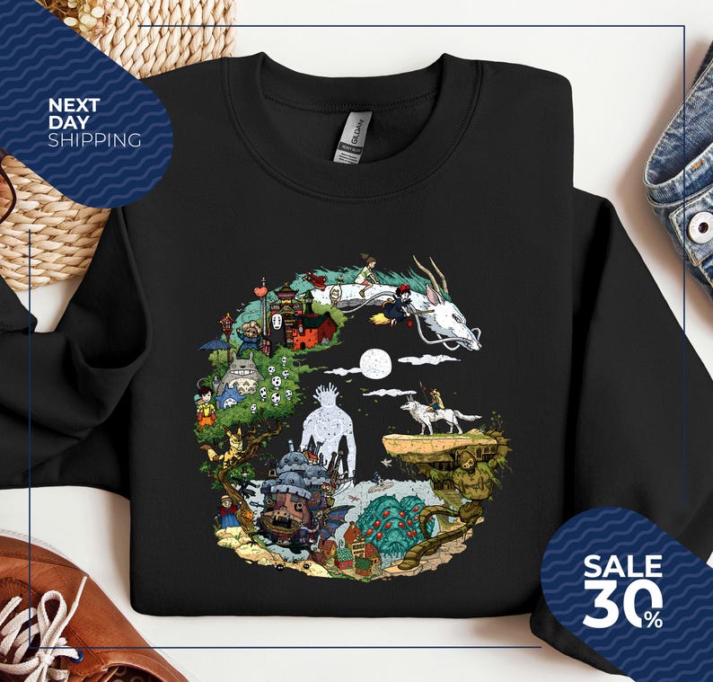a black t-shirt with a colorful graphic design depicting various characters and elements from the animated film "Spirited Away".