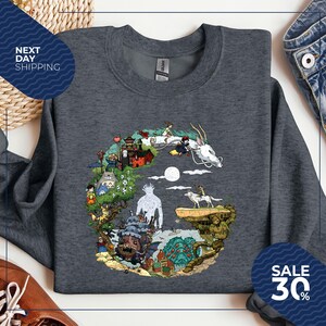 a gray sweatshirt with a colorful graphic design depicting various characters and elements from the animated film "Spirited Away".