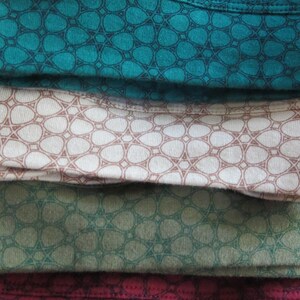May include: Four fabric swatches with a repeating geometric pattern. The swatches are teal, beige, green, and burgundy.