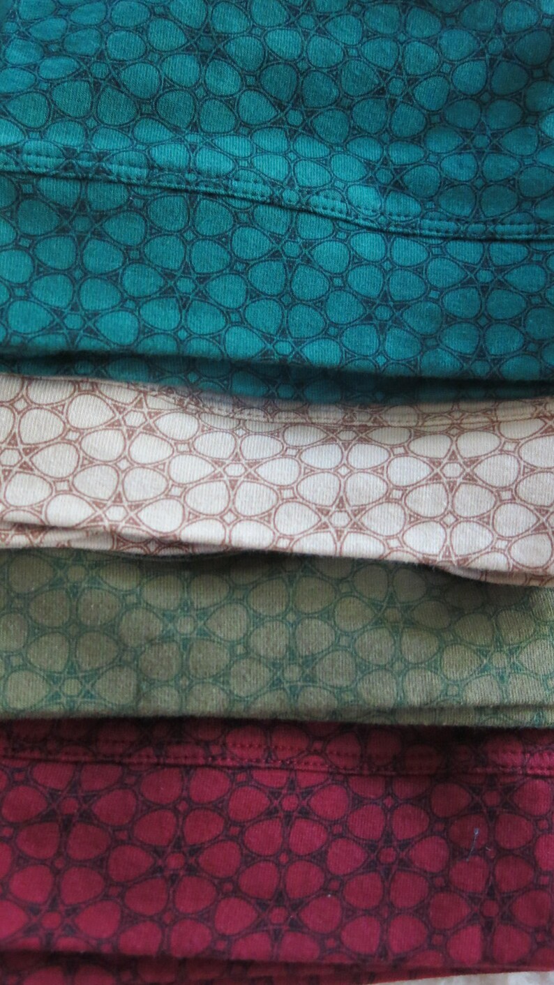 May include: Four fabric swatches with a repeating geometric pattern. The swatches are teal, beige, green, and burgundy.