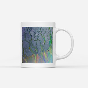 May include: White ceramic mug with a vibrant abstract design. The artwork shows a network of green, blue, and yellow lines on a grey backdrop, with a rainbow gradient at the base. The mug has a standard handle for easy use.