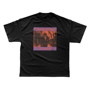 May include: Black t-shirt featuring a graphic with the text "FUTURE HNDRXX" and "THE WIZARD" in a purple and orange design. The graphic depicts a person in a forest setting. The shirt is a standard crew neck.