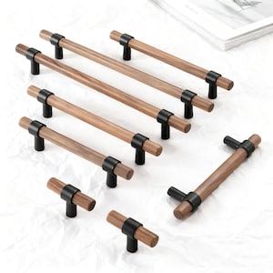 Op de afbeelding: Een verzameling houten kastgrepen met zwarte metalen accenten. De grepen hebben een natuurlijke houtnerf afwerking en zijn gerangschikt op een witte ondergrond. De hardware omvat zowel stang- als knopstijlen, geschikt voor diverse meubels.