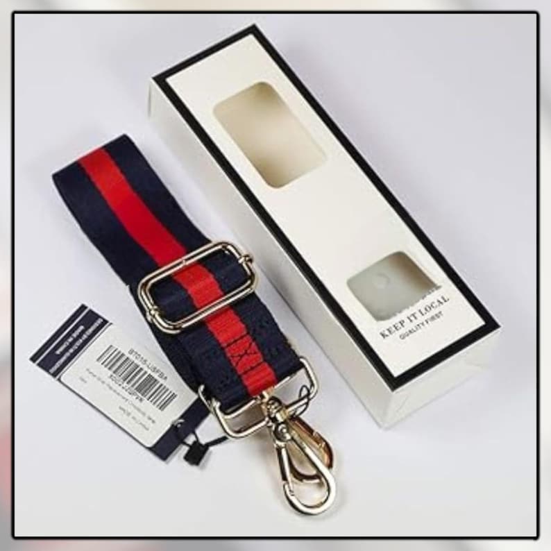 Puede incluir: Una correa de bolso a rayas azul marino y rojo con herrajes met&aacute;licos dorados. La correa est&aacute; junto a una caja blanca con el texto "KEEP IT LOCAL QUALITY FIRST". Tambi&eacute;n hay una etiqueta con un c&oacute;digo de barras.
