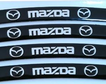 Juego de 4 pegatinas metálicas negras para llantas de rueda (9 cm) con el logotipo de Mazda. Emblemas para el centro del cubo del coche.