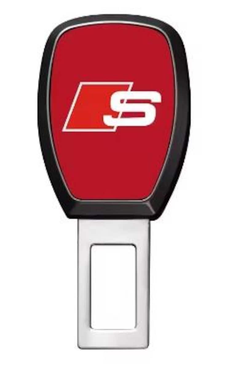 Pu&ograve; includere: Fibbia della cintura di sicurezza per auto con un design rosso e nero. La parte rossa presenta un logo "S" bianco. La fibbia &egrave; in metallo argentato.