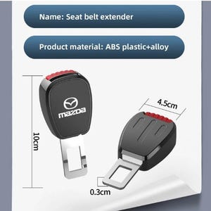 May include: Black seat belt extender with a red release button. The extender is 10 cm long and 4.5 cm wide, made of ABS plastic and alloy. The Mazda logo is visible on the front.