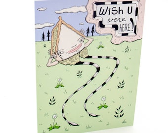 May include: A greeting card with a cartoon illustration of a person with long legs and a house for a head. The person is lying on their back in a field of grass with white flowers. The card has the text "Wish U were here!" in a speech bubble.