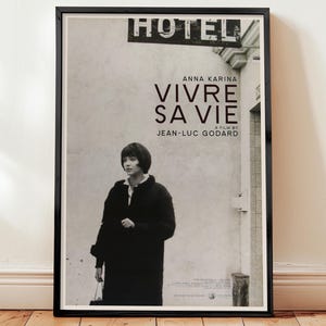 以下が含まれることがあります： ジャン＝リュック・ゴダール監督の「Vivre Sa Vie」の白黒フレーム入り映画ポスター。アンナ・カリーナが出演。ポスターはヴィンテージ感があり、タイトルは大きく太字で、黒いコートを着たカリーナの写真が掲載されています。
